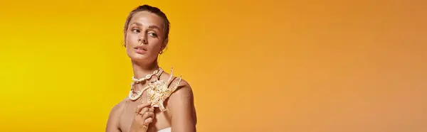 A stunning young woman gracefully poses in summer clothing, showcasing a seashell necklace, banner — Stock Photo