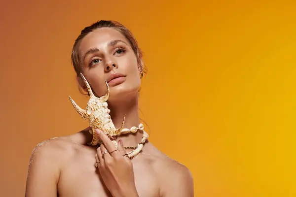 Bright studio backdrop highlights a young woman in a summer outfit with a seashell accent. — Stock Photo
