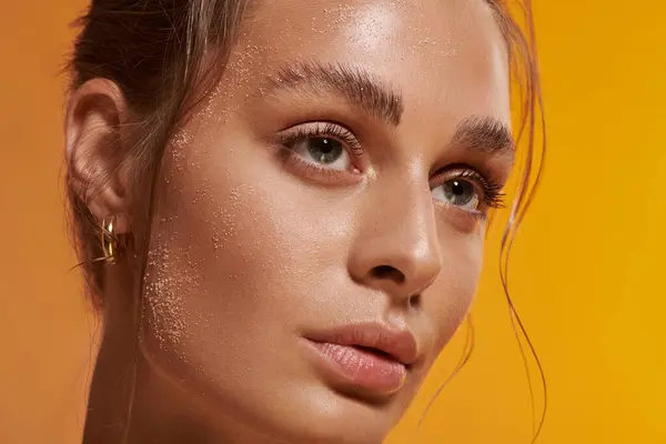 A beautiful young woman poses confidently, showcasing her beauty with sand on face — Stock Photo