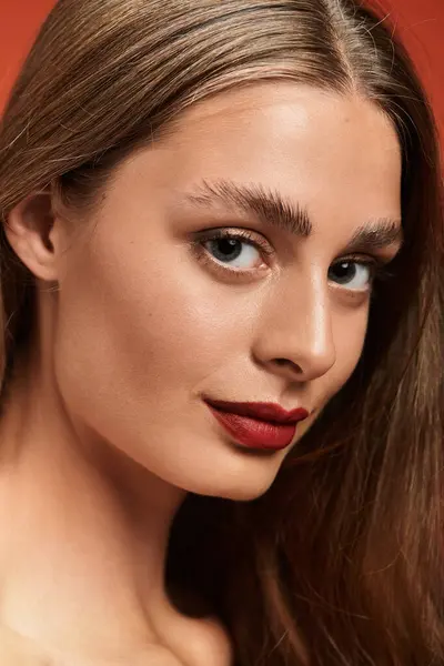 A beautiful young woman with flowing hair wears bold makeup and a confident expression. — Stock Photo