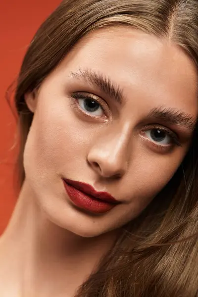 A beautiful young woman poses confidently with her long hair and bold makeup, radiating charm. — Stock Photo
