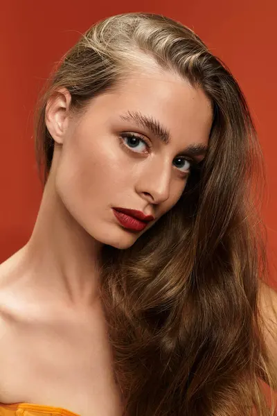 A young, beautiful woman showcases her elegance and confidence with flowing hair and bold lips. — Stock Photo