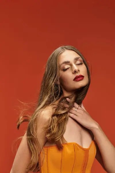 A stunning woman exudes elegance with flowing hair and radiant red lips in a pose. — Stock Photo