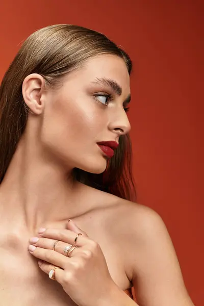 Young woman with long hair and red lips poses gracefully, showcasing her features and rings. — Stock Photo