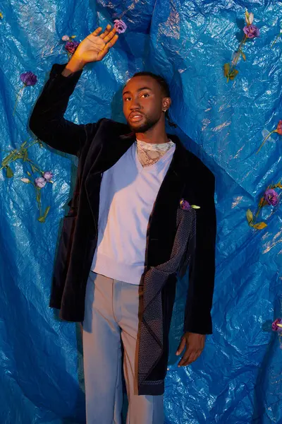 Молодой человек излучает харизму и стиль на ярком синем фоне. — стоковое фото