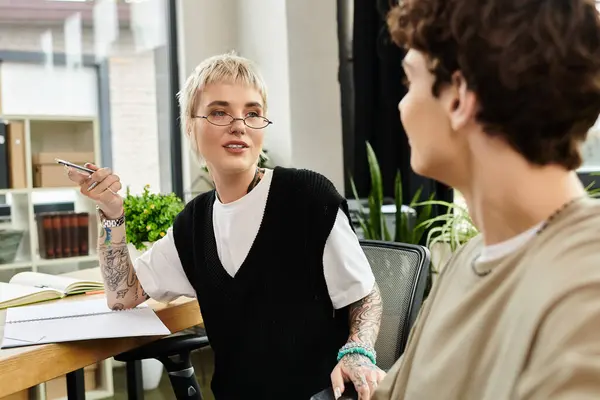 Dos jóvenes profesionales intercambian activamente ideas en una oficina moderna llena de vegetación. - foto de stock