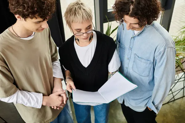 Un gruppo di giovani professionisti si concentra intensamente su un taccuino condiviso durante il brainstorming idee. — Foto stock
