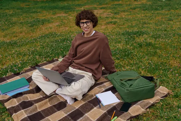 Красивый молодой студент прогуливается по пышной зеленой зоне, готовый учиться и исследовать. — стоковое фото