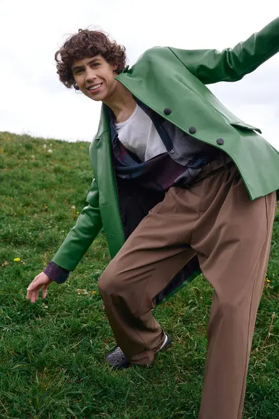 Un bellissimo studente cammina all'aperto, trasudando fiducia in abiti alla moda immersi nel verde. — Foto stock