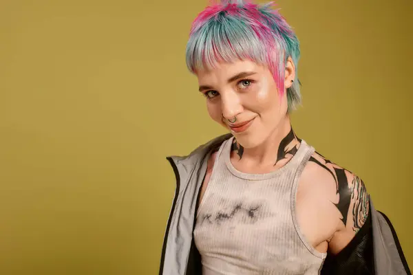 A young woman with colorful short hair poses happily in a vibrant studio space, embracing her style. — Stock Photo