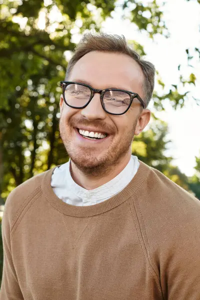 Un giovane insegnante allegro gode di una giornata di sole all'aperto, immerso nel verde e nella natura. — Foto stock