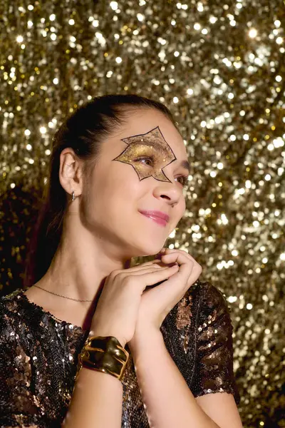 Una ragazza con una stella disegnata sul viso gode di Halloween circondata da paillettes dorate. — Stock Photo