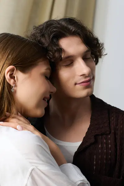 A young couple enjoys a tender embrace in their bright and stylish apartment, filled with love. — Stockfoto