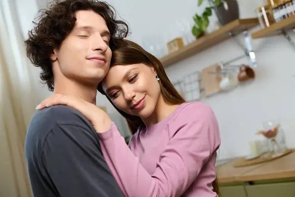 Joyful young couple embraces in their modern apartment filled with warmth and love. — Stockfoto