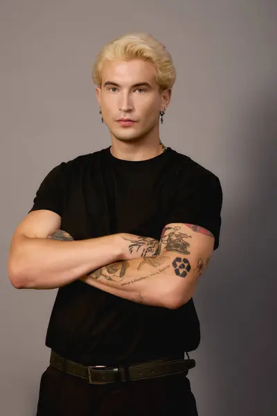 Стильний підліток впевнено стоїть з обіймами, схрещеними в сучасній обстановці. — стокове фото