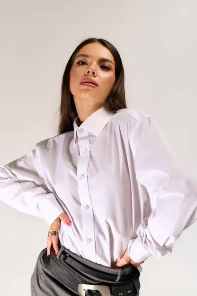 A trendy young woman poses confidently in a stylish autumn outfit featuring a white shirt and skirt. — Foto stock