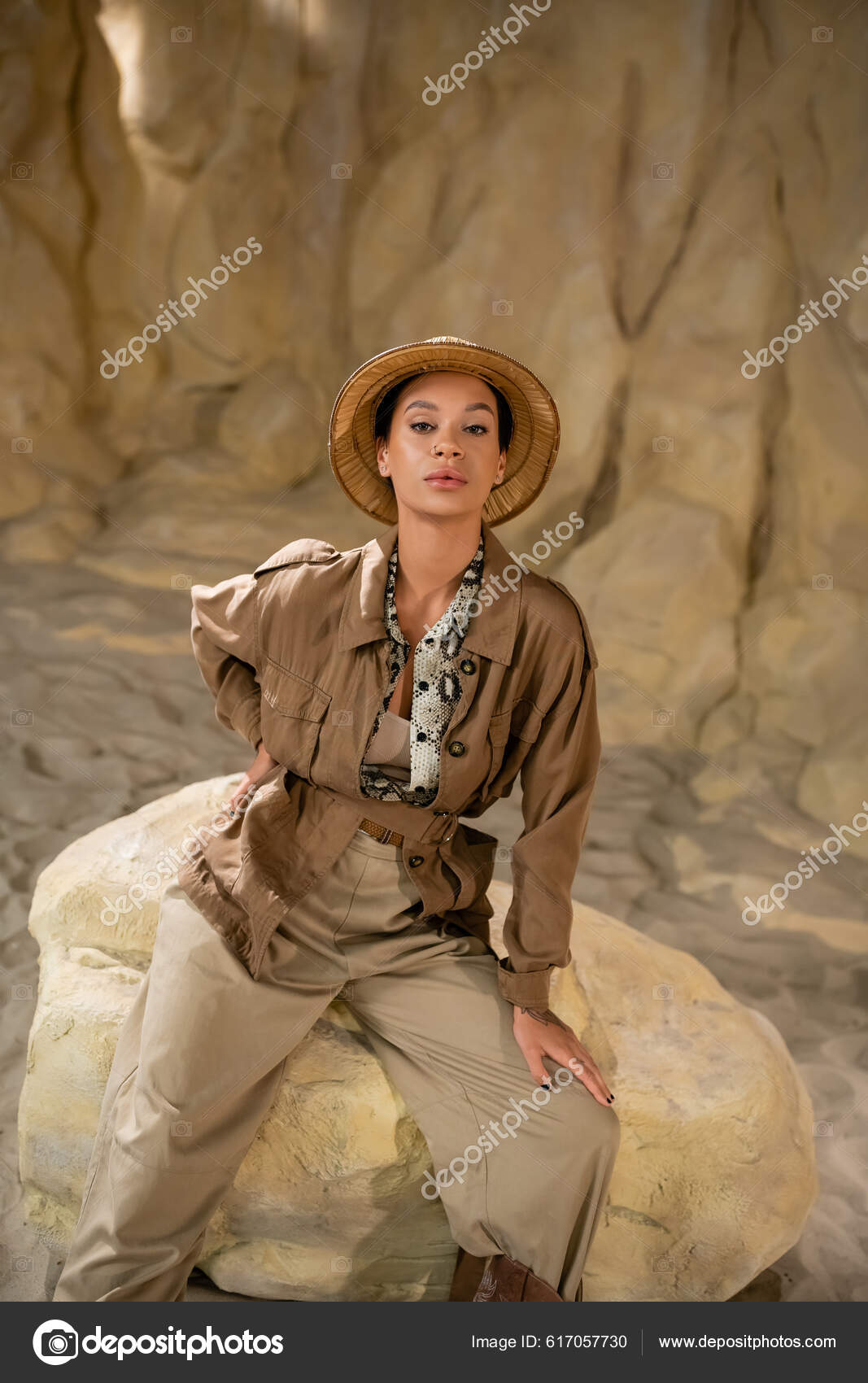 Archéologue Tenue Style Safari Assis Sur Rocher Avec Main Sur image libre  de droit par AllaSerebrina © #617057730