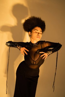 Seksi şeffaf gömlekli ve sarı sütyenli modacı Afro-Amerikan modeli. 
