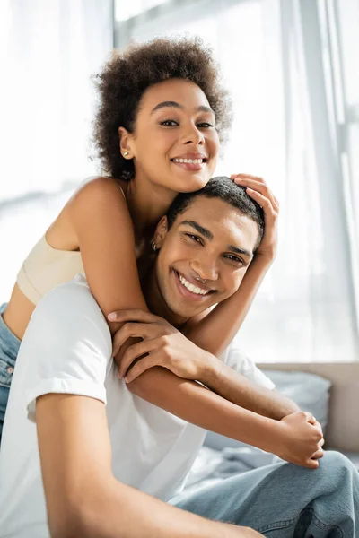 卷曲的非洲裔美国女人拥抱着快乐的男朋友 看着镜头 — 图库照片