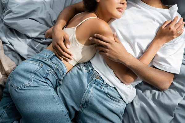 Vista Recortada Pareja Afroamericana Jeans Abrazando Mientras Está Acostado Cama — Foto de Stock
