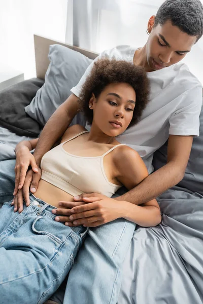 从高视角看非洲裔美国男人抚摸躺在床上的性感女友 — 图库照片
