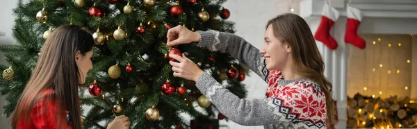 Vista Lateral Casal Lésbico Sorridente Decorando Árvore Natal Com Bolas — Fotografia de Stock