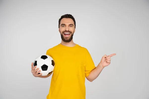 Kibic Piłki Nożnej Śmiejący Się Kamery Wskazujący Palcem Trzymając Piłkę — Zdjęcie stockowe