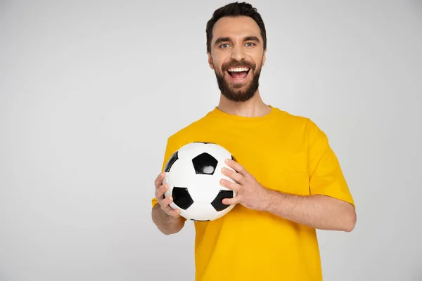 Vzrušený Vousatý Fotbalový Fanoušek Žlutém Tričku Držící Míč Smějící Kameře — Stock fotografie