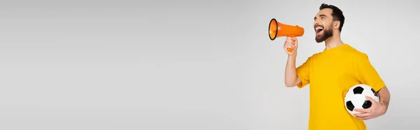 Збуджений Спортивний Вентилятор Жовтій Футболці Тримає Футбольний Кричить Мегафоні Ізольовано — стокове фото
