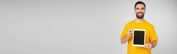 Усміхнений Чоловік Жовтій Футболці Тримає Цифровий Планшет Порожнім Екраном Ізольовано — стокове фото
