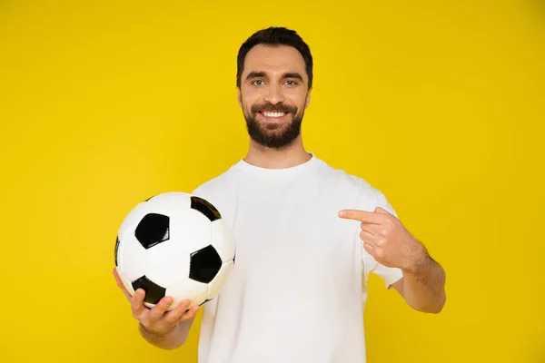 Radostná Brunetka Muž Bílém Tričku Ukazuje Fotbalový Míč Izolované Žluté — Stock fotografie