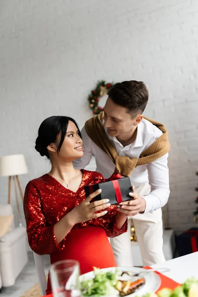 Happy Man Presenting Christmas Gift Pregnant Asian Wife Red Elegant — Stock Photo, Image