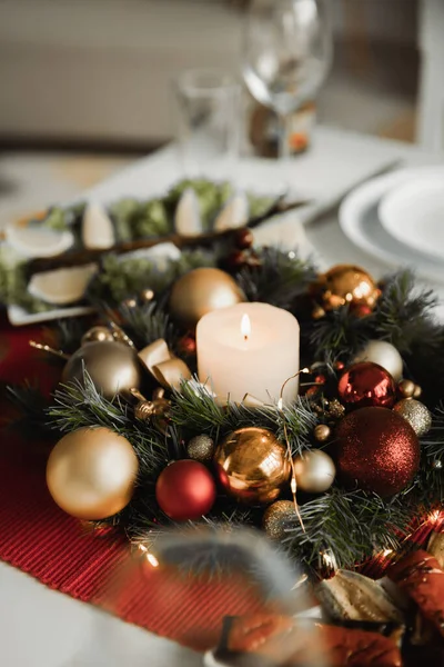 Γιορτινό Στεφάνι Χριστουγέννων Αναμμένο Κερί Και Γυαλιστερά Μπιχλιμπίδια Στο Τραπέζι — Φωτογραφία Αρχείου