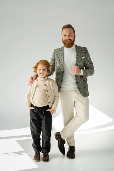 Trendy Bebaarde Vader Roodharige Zoon Poseren Grijze Achtergrond Met Zonlicht — Stockfoto