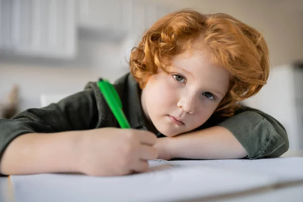 Unatkozik Vörös Hajú Fiú Tollal Nézi Kamera Közelében Elmosódott Notebook — Stock Fotó