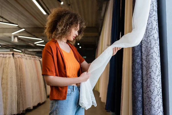 Side View Young Curly Woman Touching Curtains Textile Shop — Stock Photo, Image
