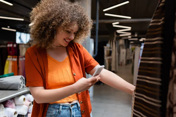 Smiling Customer Using Smartphone Blurred Fabric Samples Shop — Stock Photo, Image