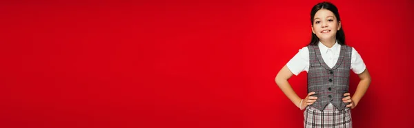 Школьница Клетчатой Одежде Стоя Руками Бедрах Изолированы Красный Баннер — стоковое фото