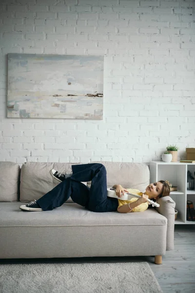 Plná Délka Dívky Sluchátkách Ležící Gauči Moderním Obývacím Pokoji Hrající — Stock fotografie