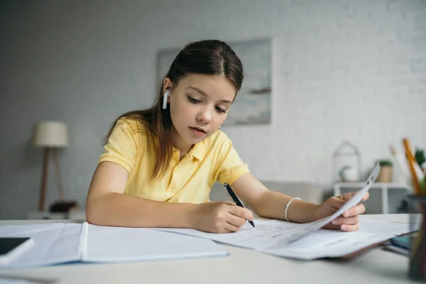 Brunette Schoolgirl Wireless Earphone Writing Looking Copybook Home — Stock Photo, Image