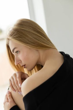 Evde çıplak pozlar veren baştan çıkarıcı sarışın kadın profili.