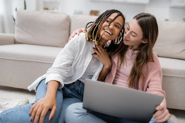 stock image tattooed african american woman smiling while showing engagement ring near happy girlfriend during video call 