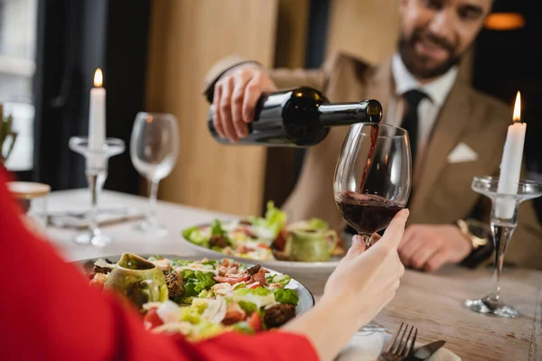 Uomo Sfocato Versando Vino Rosso Nel Bicchiere Fidanzata Durante Cena — Foto Stock