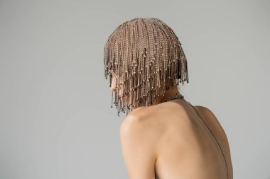 Model with naked shoulders and jewelry headwear isolated on grey  