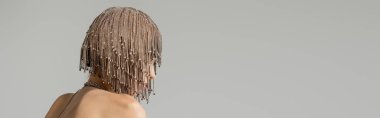 Woman in jewelry headwear standing isolated on grey with copy space, banner 