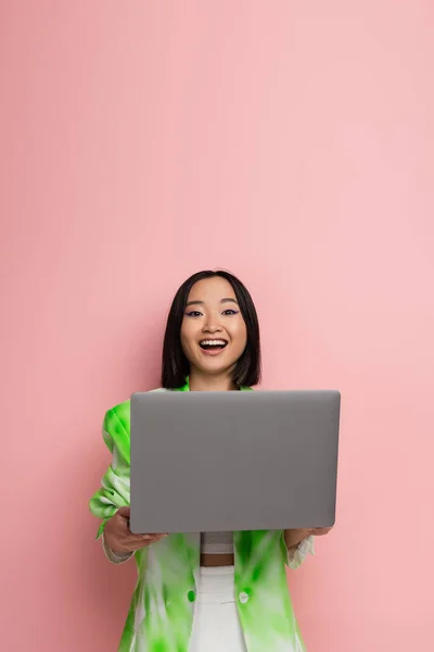Amazed Asian Woman Trendy Clothes Looking Camera Laptop Isolated Pink —  Fotos de Stock