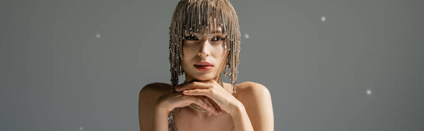 young woman with metallic jewelry headwear posing while looking at camera on grey, banner 
