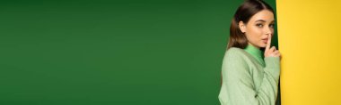 Young teen girl in jumper showing secret sign on colorful background, banner 