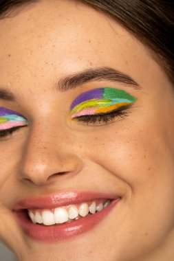 Close up view of happy teen girl with creative makeup closing eyes clipart