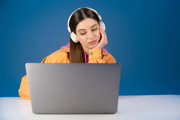 Brunette Teenager Headphones Looking Laptop Table Isolated Blue — Foto Stock